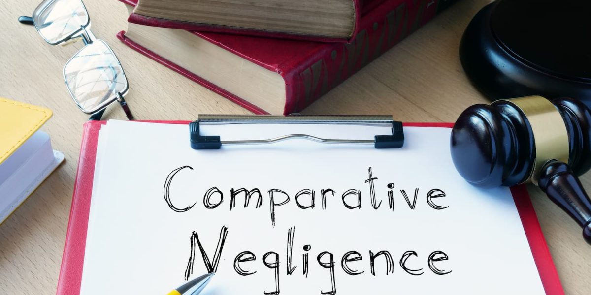 Comparative negligence concept with law books, gavel, glasses, and clipboard on desk representing California personal injury law.